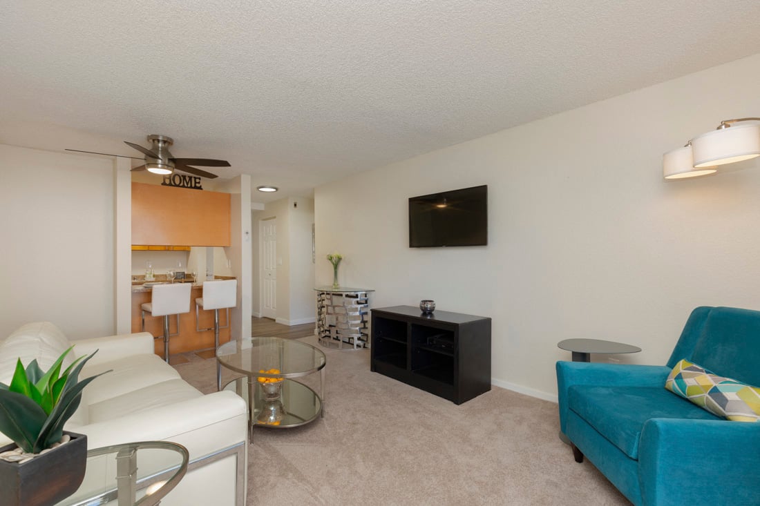 a living room with a blue couch and a glass table